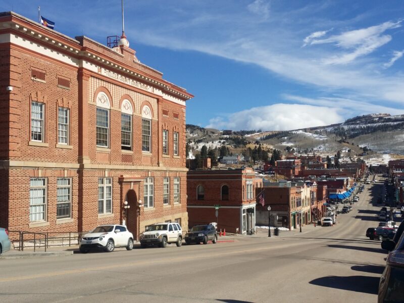 The red-brick Teller County Courthouse overlooking downtown Cripple Creek and snow-dusted hills.